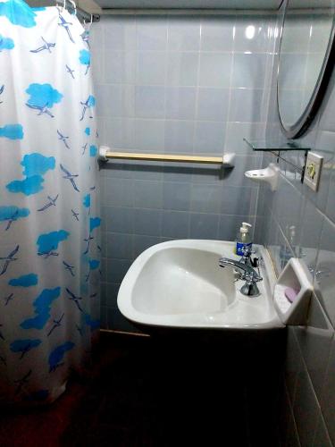 a bathroom with a sink and a shower curtain at Casa Chalet 6 personas in Cosquín