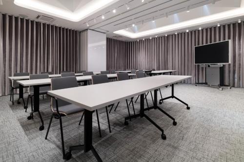 a conference room with tables and chairs and a tv at Wings Plaza in Kraków