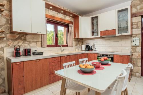a kitchen with a table with a bowl of fruit on it at Arca Villa - Enchanting Sunset! in Keri