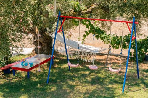 a swing set in a yard with a playground at Arca Villa - Enchanting Sunset! in Keri