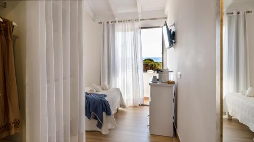 a room with white walls and a door with a window at Hotel Rosamar - Emar Hotels in Es Pujols