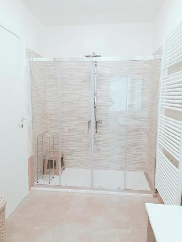 una ducha con puerta de cristal en un baño en Appartamento Julia Trilocale Open Space - Tolmezzo UD, en Tolmezzo