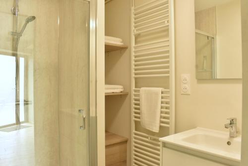 a white bathroom with a shower and a sink at Gîte La Mancellière - Maison familiale 12pers, grand jardin, jeux & pétanque - Pleine nature 