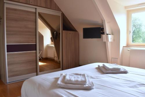 a bedroom with a bed with two towels on it at Gîte La Mancellière - Maison familiale 12pers, grand jardin, jeux & pétanque - Pleine nature 