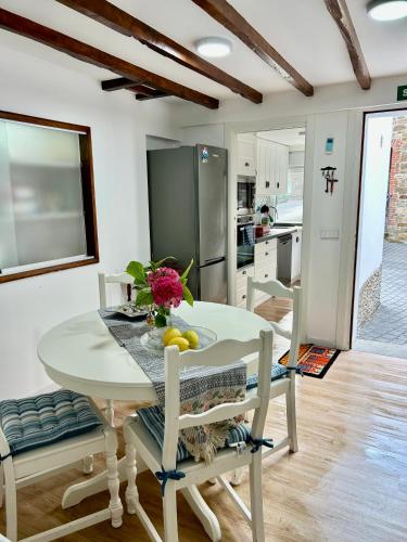 a kitchen and dining room with a white table and chairs at Casa Nel in Abándames