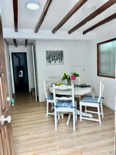 a dining room with a white table and chairs at Casa Nel in Abándames