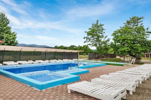 a swimming pool with white lounge chairs around it at Dana NEW 2025 in Solotvyno