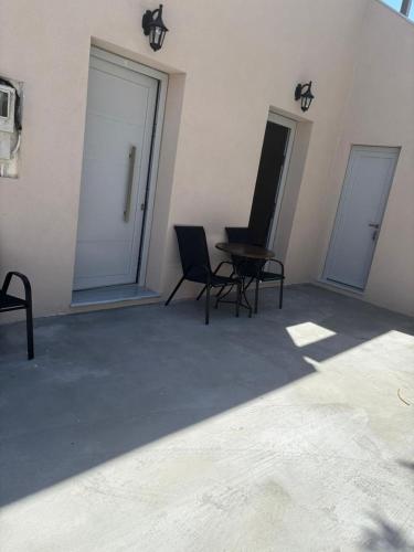 a room with two chairs and a table and two doors at Sunset Realty Studios in Kinion