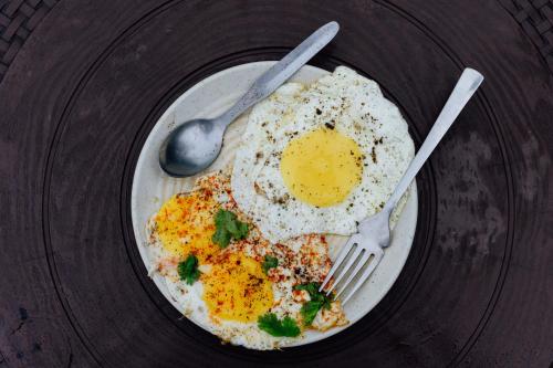 a plate with a fried egg and a fork and knife at Urban Loft Hostel in Rishīkesh