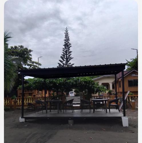 a pavilion with tables and chairs and a tree at Seabreeze Beachfront Home and Cottages new management in San Juan