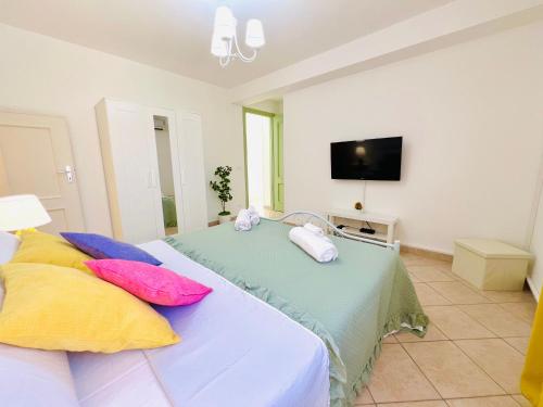 a bedroom with a bed with pillows and a tv at Palmira in Isola delle Femmine