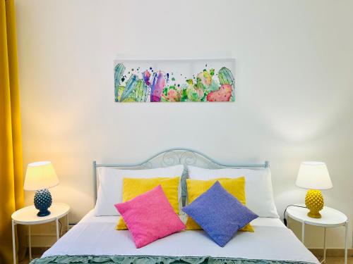 a bedroom with a bed with colorful pillows at Palmira in Isola delle Femmine