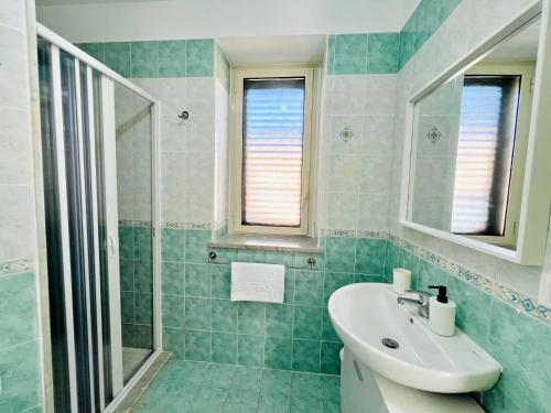 a bathroom with a sink and a shower at Palmira in Isola delle Femmine