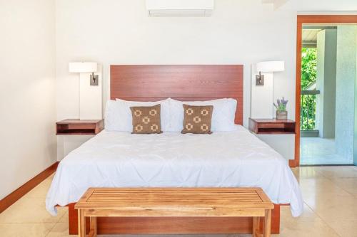 une chambre avec un lit blanc avec une tête de lit en bois dans l'établissement Hanalei Bay Resort 7308, à Princeville