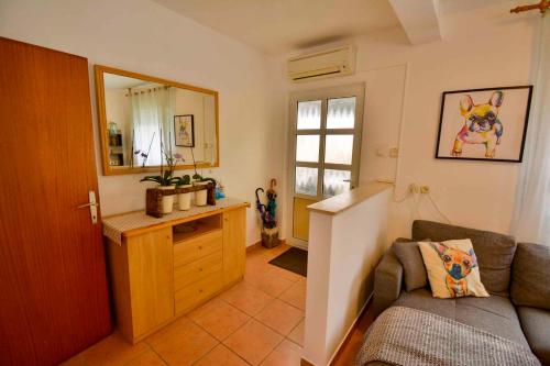 salon z kanapą i lustrem w obiekcie Apartment in Banjol - Insel Rab 26609 w mieście Banjol