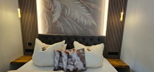 a bed with white pillows and a painting on the wall at Home sweet Home in Havelberg