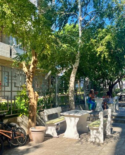 a park with a tree and a table and benches at STELA in Nesebar