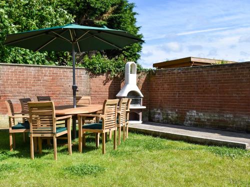 a table and chairs with an umbrella in the grass at The Bungalow in Staithes