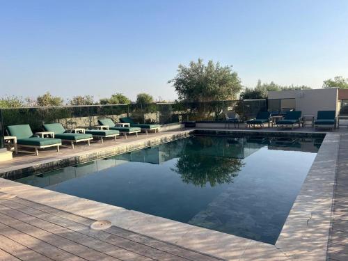 マラケシュにあるM Résidence Marrakech Luxury Serviced Apartmentsのスイミングプール(ラウンジチェア、椅子付)