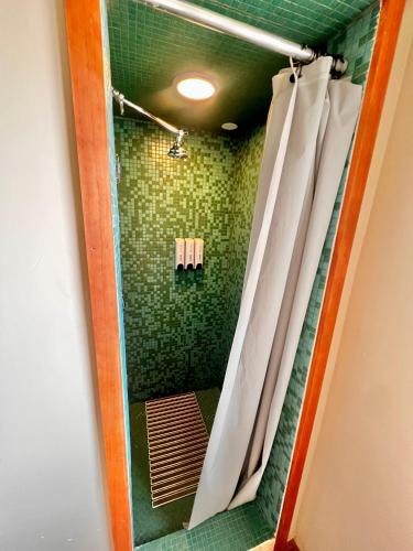 a bathroom with a shower with green tiles at Room 5 - Downtown Joshua Tree Motel - Pet Friendly - Walk to Shops & Visitor Center, Minutes to Park Entrance in Joshua Tree