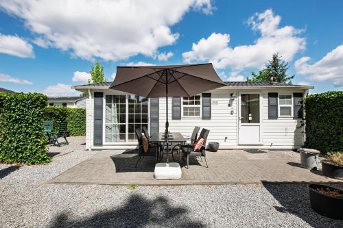 a patio with a table and an umbrella at 85, Private, Parking - Nature - Central - AC - Serene! in Oisterwijk