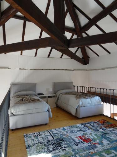 a bedroom with two beds and a rug on the floor at Mia Experience Lake Como in San Fermo della Battaglia