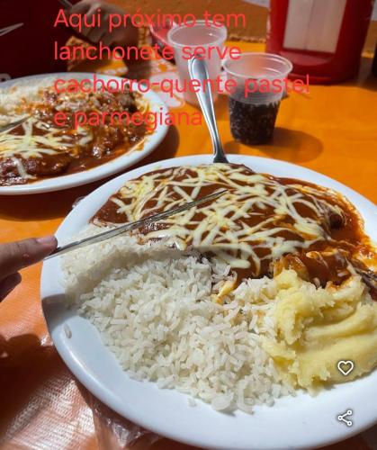 a plate of food with rice on a table at Hospedagem Sousa Santos in Montes Claros