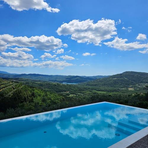 a swimming pool with a view of the mountains at Villa with Private Pool & Lake View near Motovun, Casa Mille Olivi Modern in Buzet