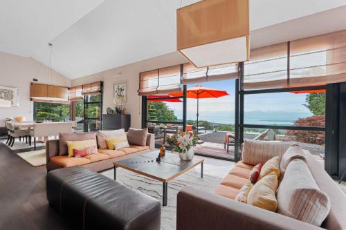 a living room with a couch and a table at Exquisite 5-Bedroom Villa in Arzier for Families by GuestLee in Arzier