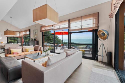a living room with a couch and a table at Exquisite 5-Bedroom Villa in Arzier for Families by GuestLee in Arzier