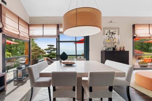 a dining room with a white table and chairs at Exquisite 5-Bedroom Villa in Arzier for Families by GuestLee in Arzier