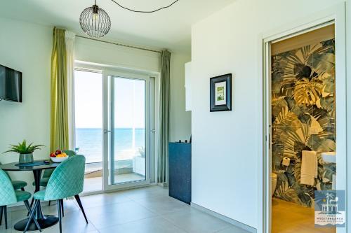 a dining room with a table and a view of the ocean at Villa Mediterranea Apartments - Seaview, Pool & Garden in Bari