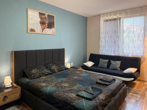 a bedroom with a bed and a couch at Briz MK Apartment in Ravda