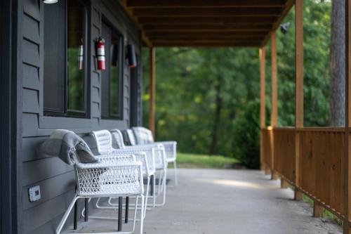a row of white chairs on a porch at The Woodsman Lodge in Eureka Springs