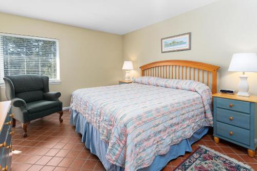 a bedroom with a bed and a chair and a window at Shipwatch #312 in East End