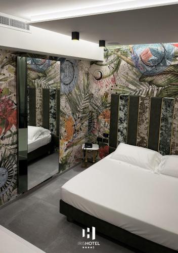 a bedroom with a bed and a wall with a mural at Iris Hotel in Erbusco