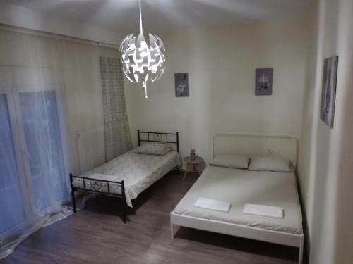 a bedroom with two beds and a chandelier at Kota Apartman in Stavros