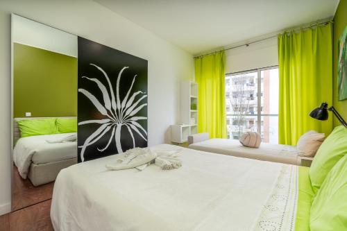 1 dormitorio con 2 camas y una ventana con cortinas amarillas en FozPalace Residence SPA, en Portimão