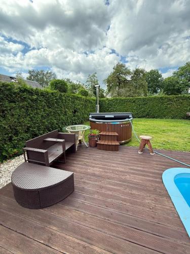 a wooden deck with benches and a swimming pool at Amber Villa in Rīga
