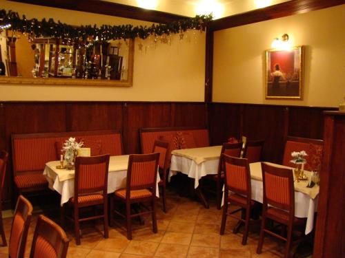 a dining room with two tables and chairs and a mirror at Hotel Centras in Šakiai