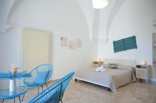 a bedroom with a bed and two blue chairs at A L Tourist House - La Corte Bianca - La Torre Blu in Carovigno