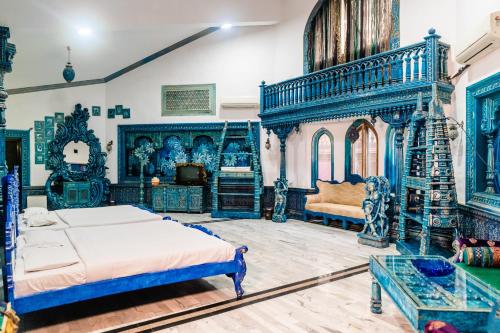 a bedroom with blue and white furniture and a bed at Aayush Resort in Kālundri