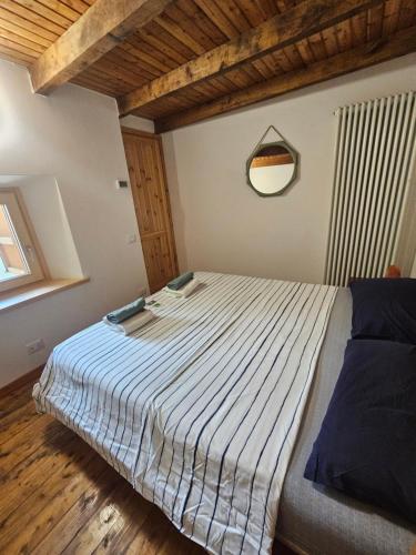 Un dormitorio con una cama con un edredón azul y blanco. en Vecchio fienile la torre, en Valbondione