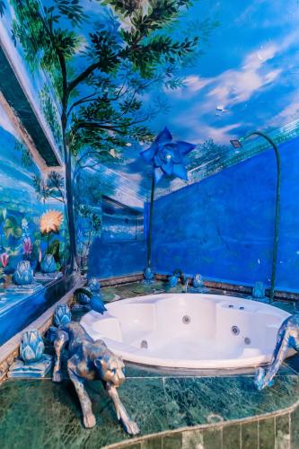 a room with a bath tub in a blue room at Aayush Resort in Kālundri