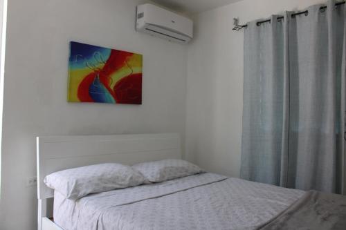 a bedroom with a bed and a painting on the wall at Bayamon Metro City View in Bayamon