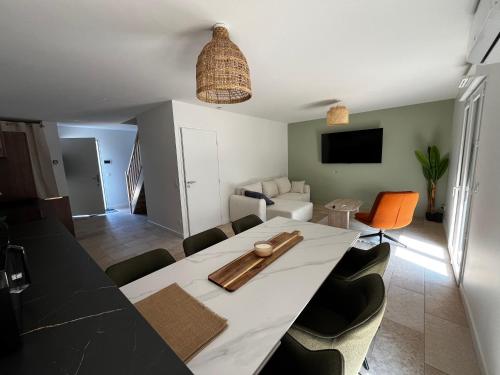une salle à manger avec une table et un salon dans l'établissement Villa Climatisée 8 Pers, 4 chambres, 3 Sdb, à Saubion