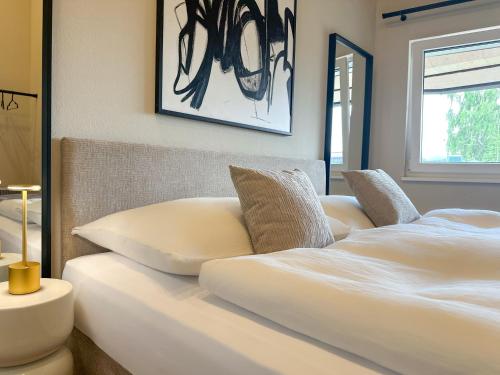 a bed with two pillows on it in a room at "FIVE" Premium Apartments Seekirchen - exklusive 4-Zi-Penthouse-Wohnung in Seekirchen am Wallersee