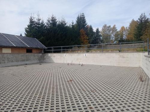 a empty parking lot with a fence and trees at Apartments Bayer - ex Apartments Pavel in Abertamy