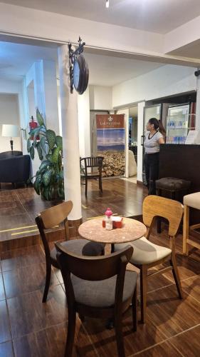 a lobby with a table and chairs and a woman at Duquesa Valentina Hotel in Salta