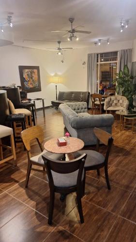 a living room with couches and tables and chairs at Duquesa Valentina Hotel in Salta